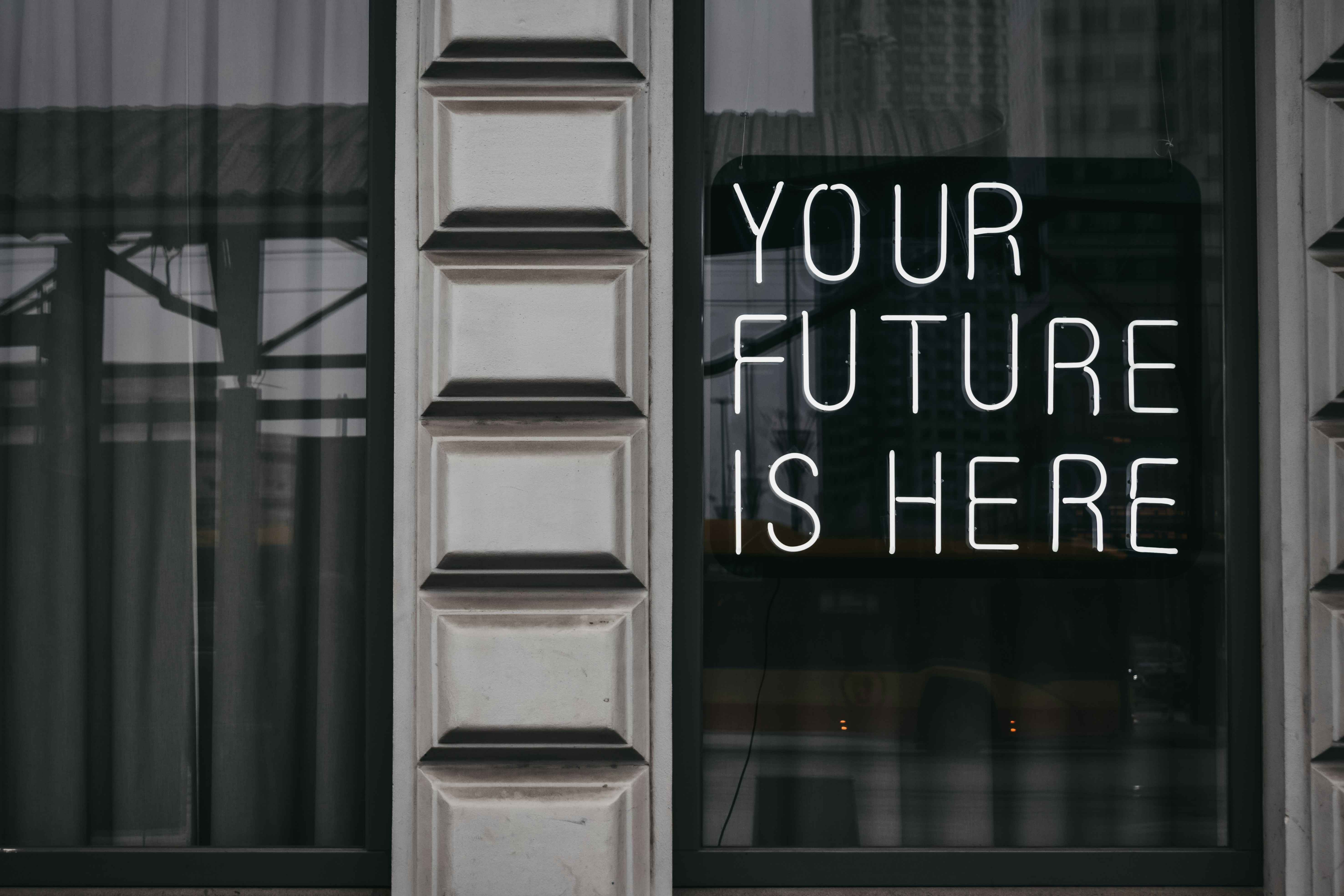 An image of a modern looking storefront with the words 'Your Future Is Here' written in white on the front glass. This image can be downloaded from Unsplash as stock photography.